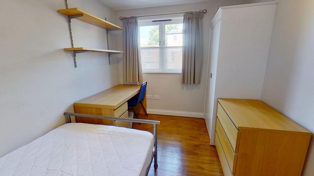 Bright, neatly furnished single bedroom with wo...