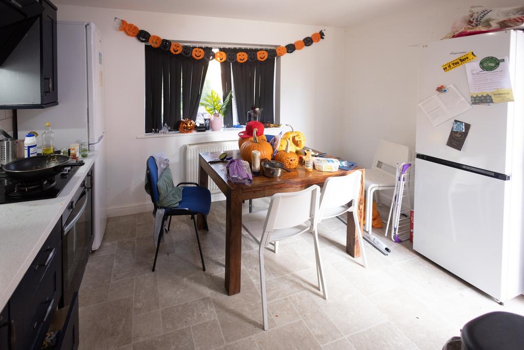 A functional kitchen area with a wooden dining ...