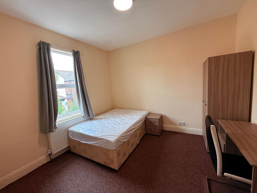 Bright, simply furnished bedroom with a large w...