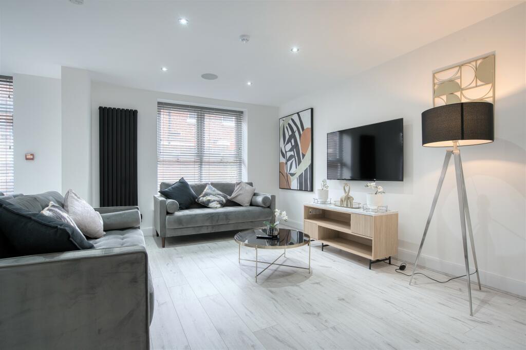 A modern, well-lit living room featuring comfor...