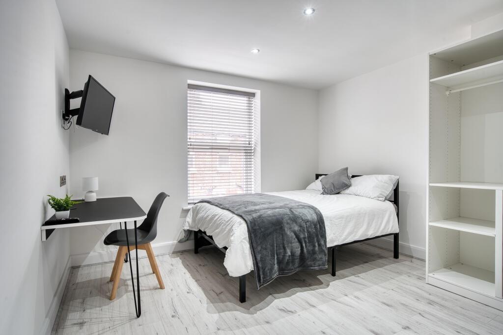 Bright and tidy student bedroom featuring a dou...