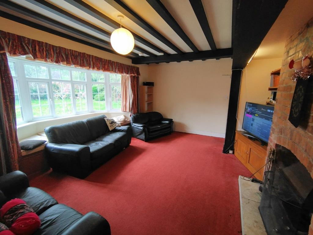 Bright living room with a large bay window over...