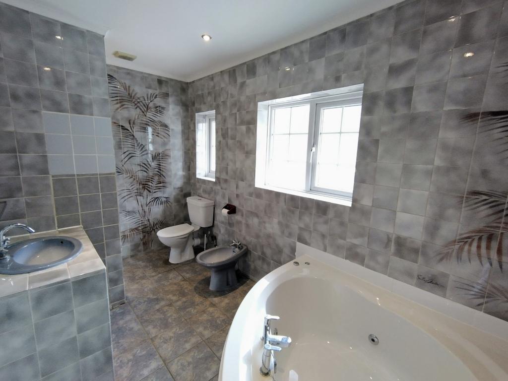 Well-appointed bathroom with a corner whirlpool...