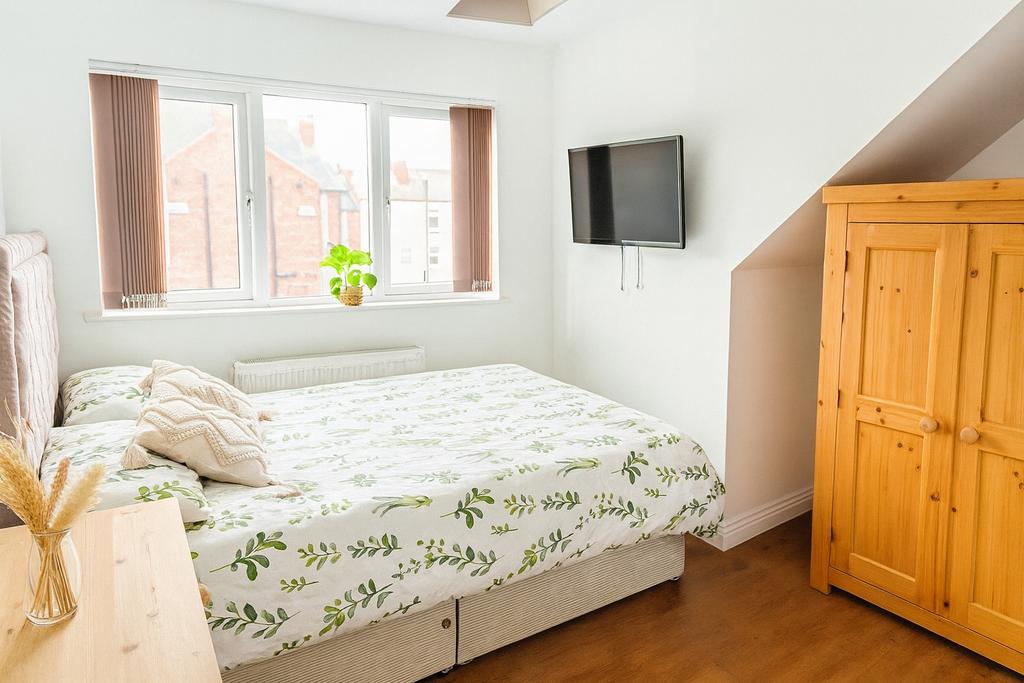 A bright and tidy double bedroom featuring a co...