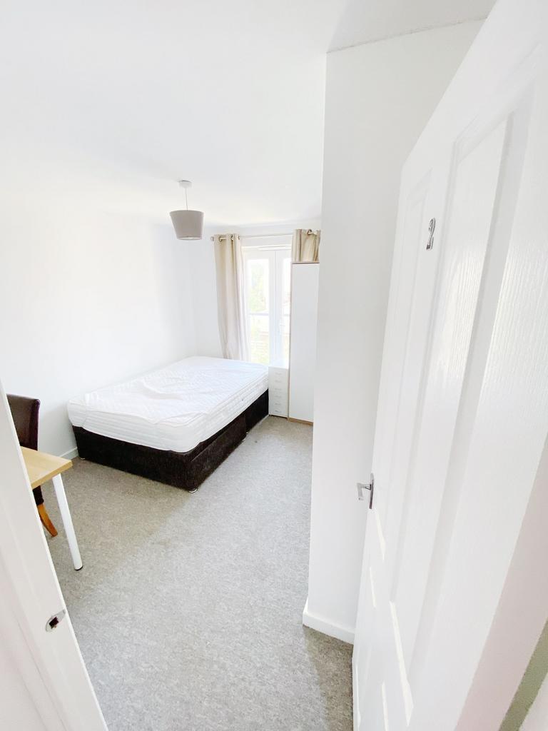 Bright, neutrally decorated bedroom with a doub...