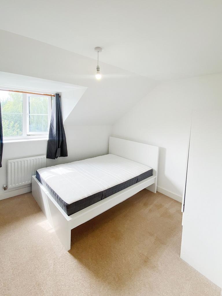 Bright, tidy bedroom with a modern white bed fr...