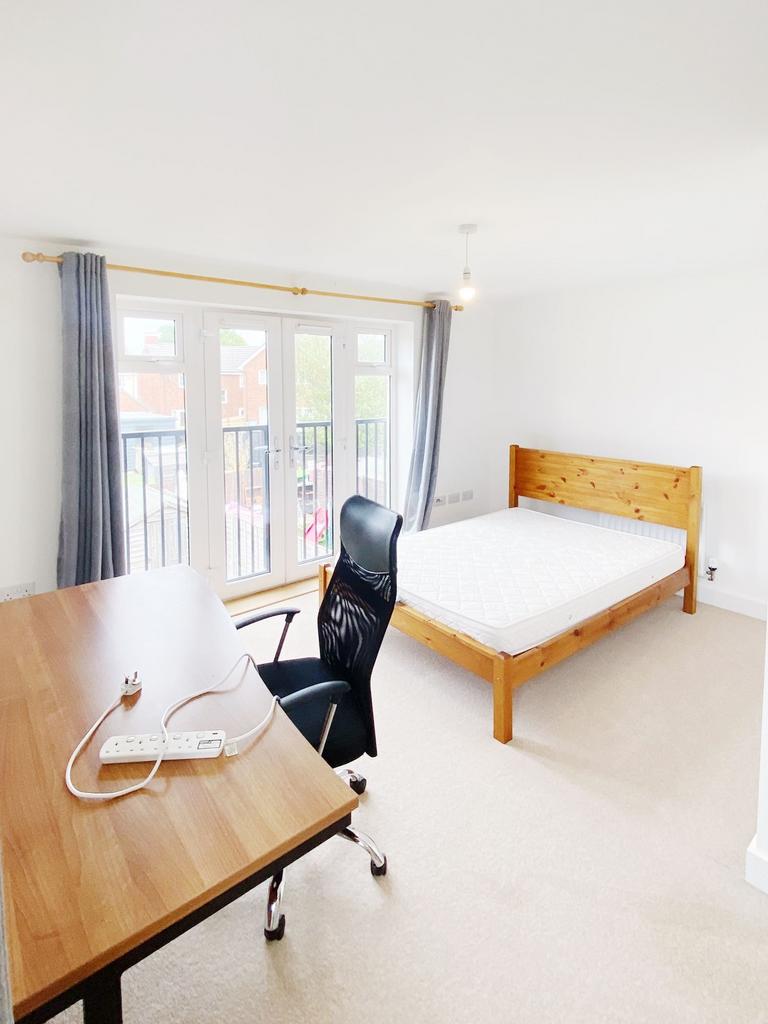 Bright, well-presented bedroom with a wooden do...