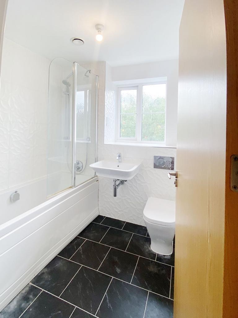 Bright, modern bathroom with a combined bath an...