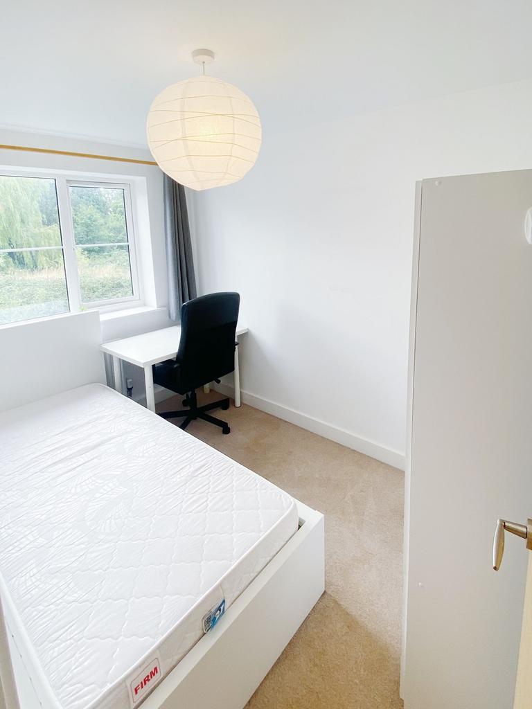 Bright, freshly painted bedroom with a comforta...