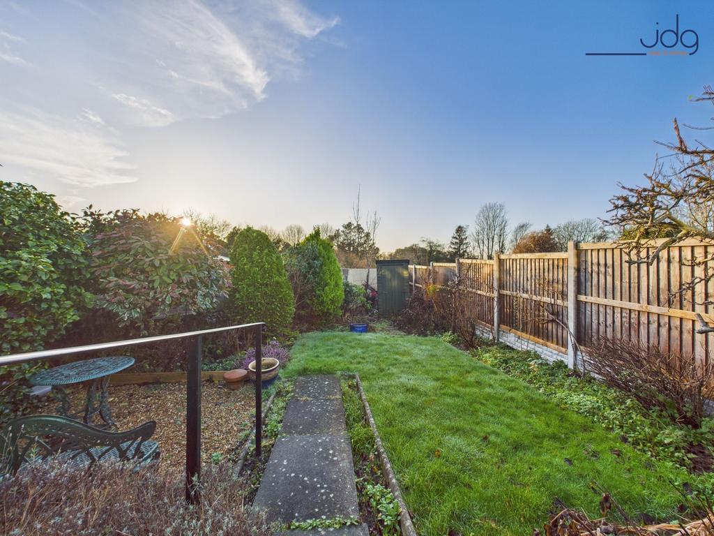 A generous, tiered rear garden with paved...