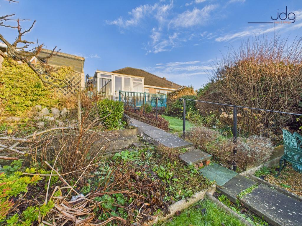 A generous, tiered rear garden with paved...