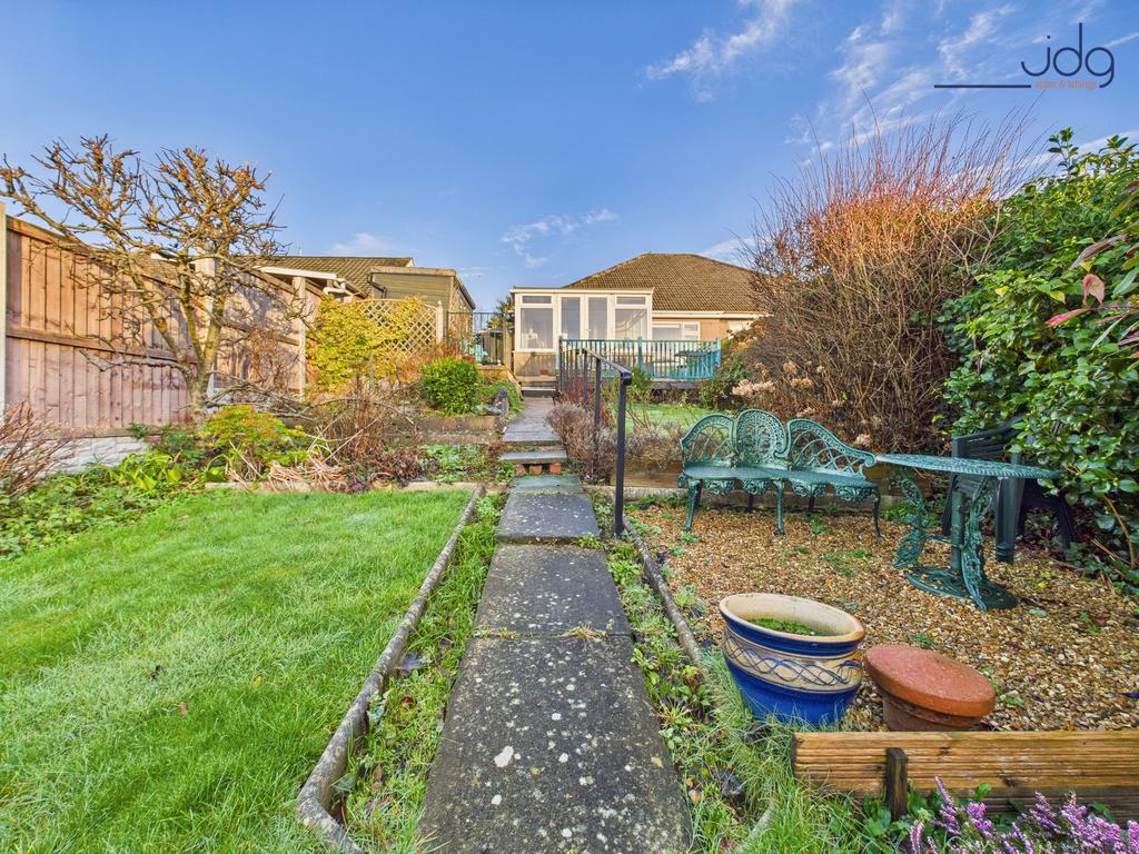 A generous, tiered rear garden with paved...