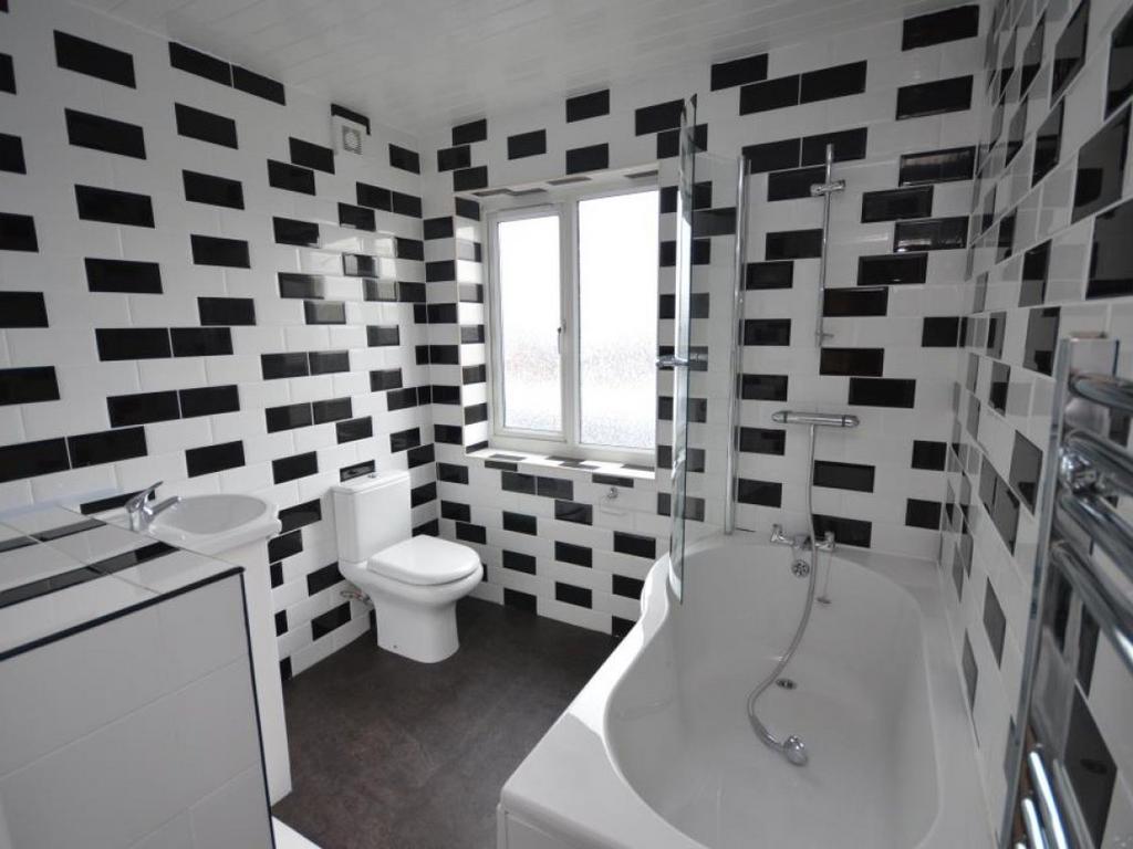 Modern bathroom featuring geometric black and w...