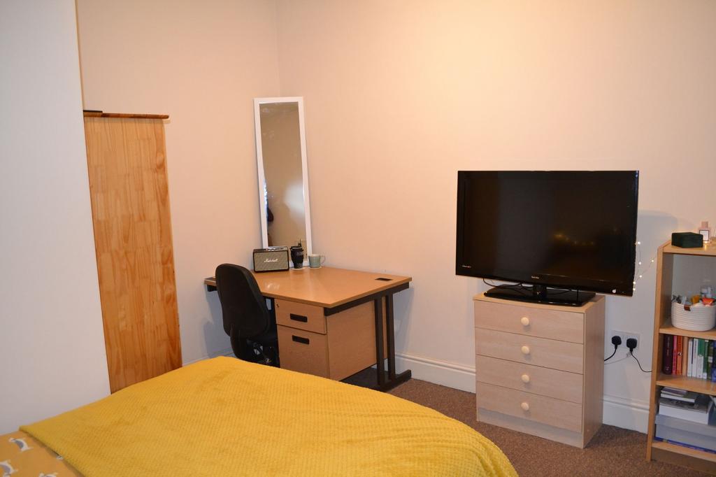 A cozy double bedroom featuring a neatly made b...