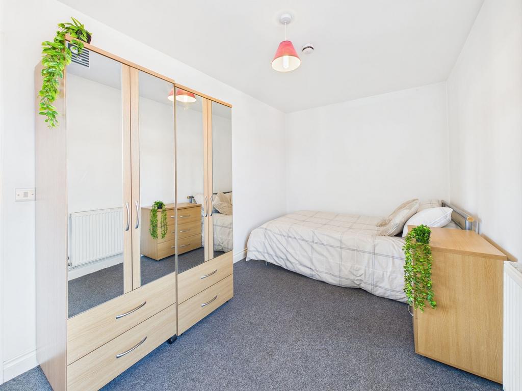 A cozy student bedroom featuring a single bed, ...