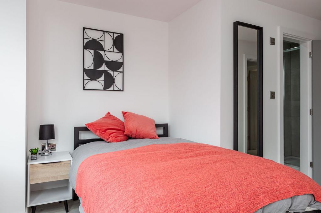 A modern bedroom featuring a comfortable double...