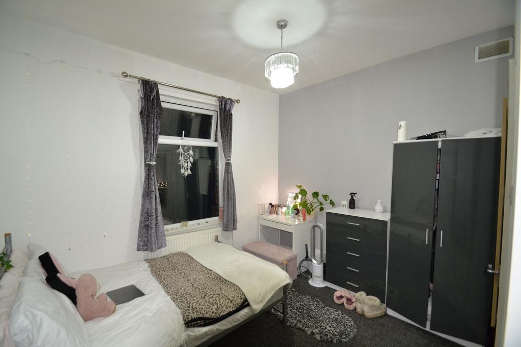 Bright, neatly furnished bedroom with a double ...