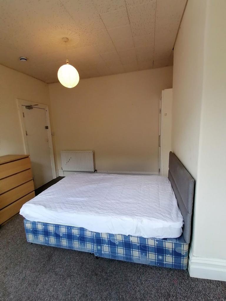 Bright, simply furnished bedroom with a double ...