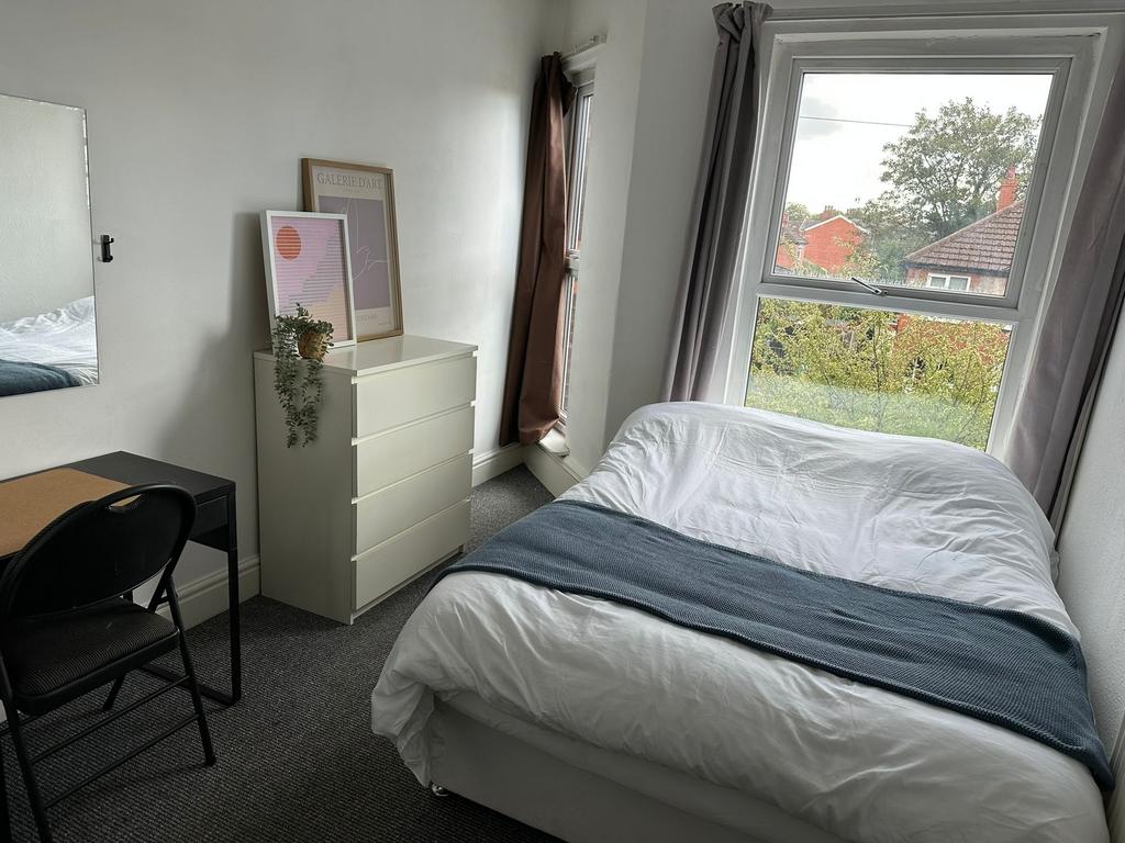 Bright and cozy bedroom featuring a large windo...