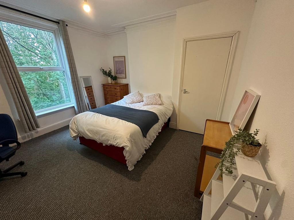 A cozy bedroom featuring a double bed with two ...