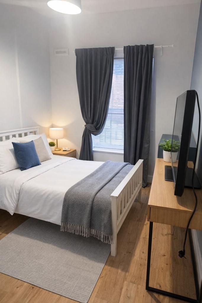 Bright, neatly styled bedroom with a white wood...