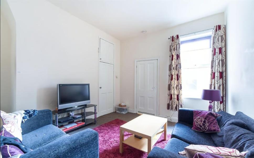 Bright, comfortable living room with two navy s...