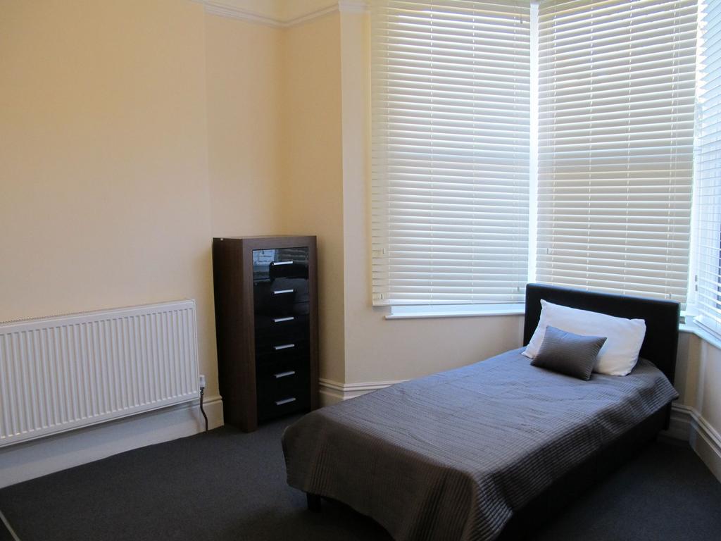 Bright, simply furnished single bedroom with a ...