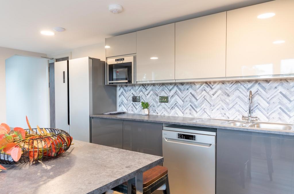 A modern and stylish kitchenette featuring slee...