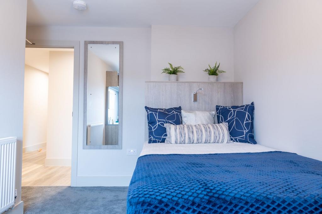 A bright, modern bedroom featuring a cozy bed w...