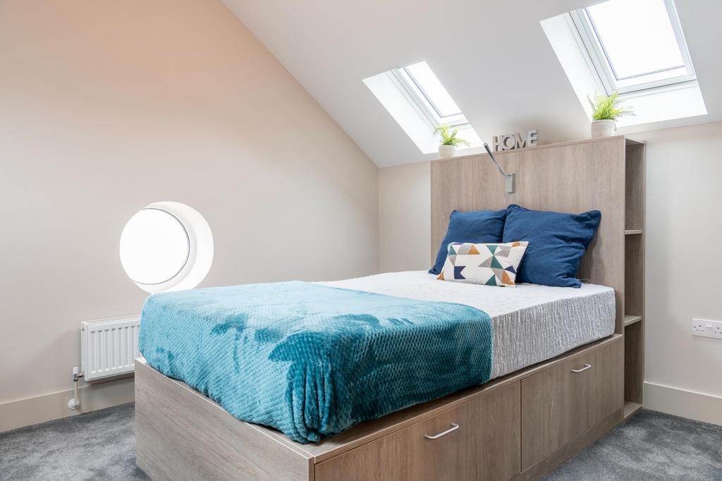 A stylish double bedroom featuring bright skyli...