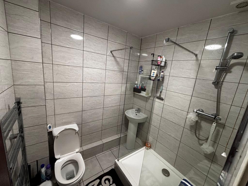 Modern tiled bathroom with a walk-in shower, pe...