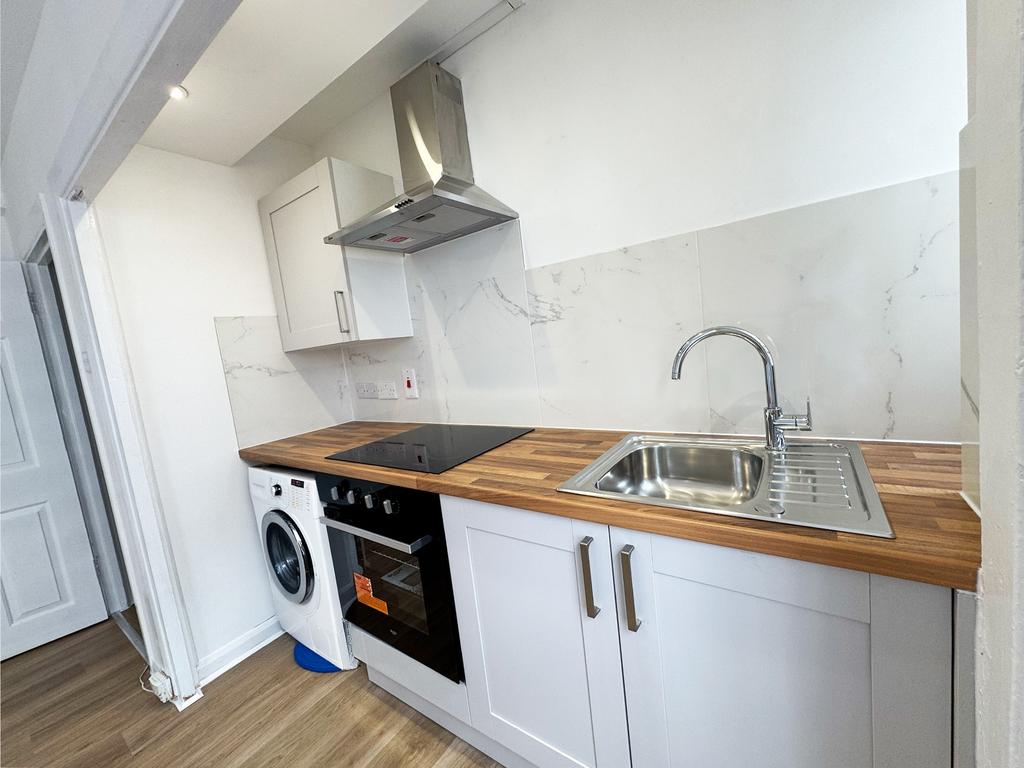 Bright modern galley-style kitchen with wood-ef...