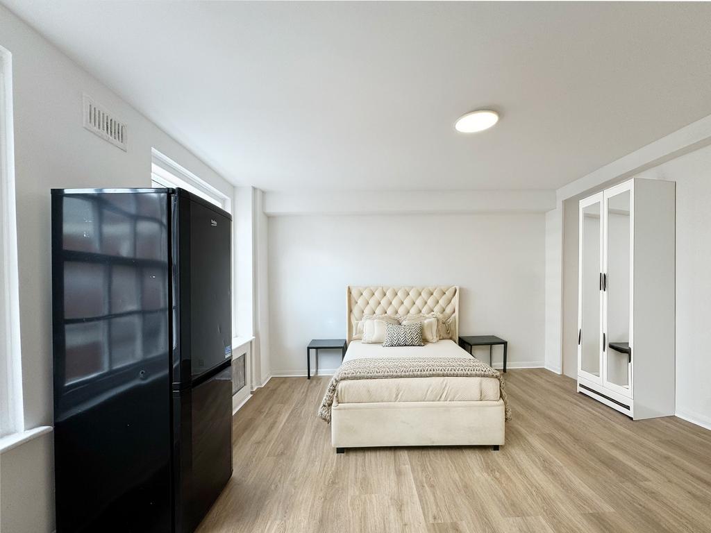 Bright, modern double bedroom with a plush upho...