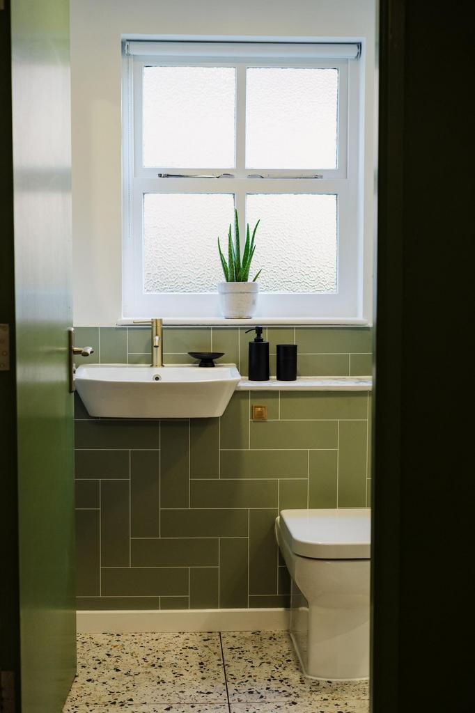Bright and tidy bathroom featuring a modern sin...