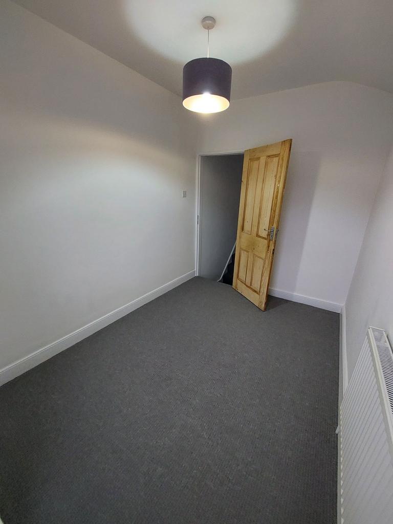 Simple, freshly painted single bedroom with neu...