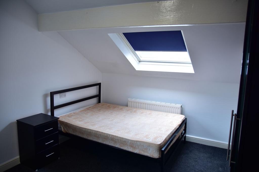 A bright and cozy bedroom featuring a skylight ...