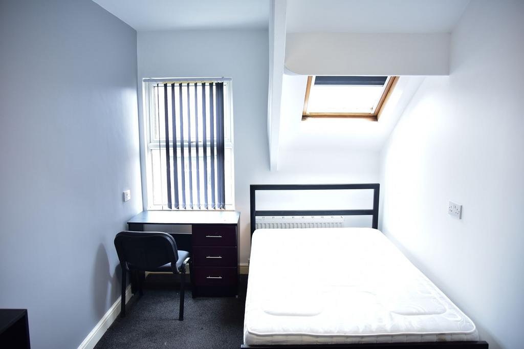 A bright and tidy bedroom featuring a comfortab...