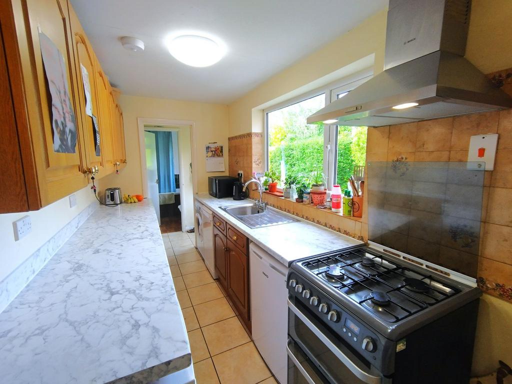 Bright galley kitchen with marble-effect workto...