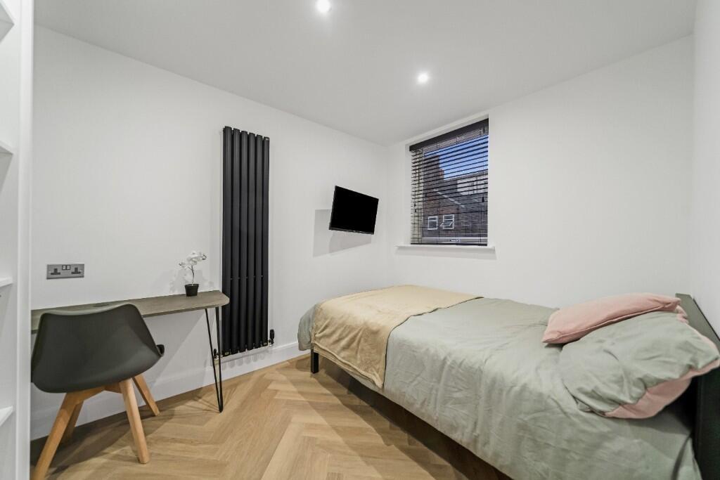 A bright and tidy single bedroom featuring a co...