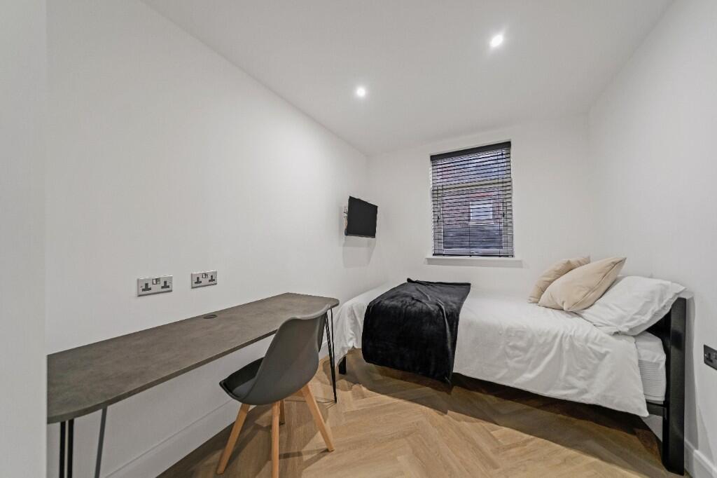 A bright, modern bedroom featuring a comfortabl...