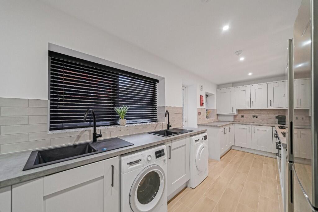 Bright and modern kitchen with ample storage, f...