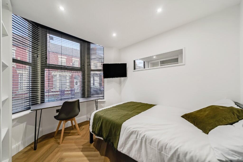 A bright and modern student bedroom featuring a...