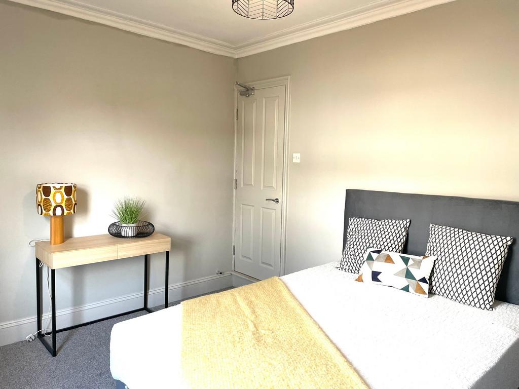 A bright and modern double bedroom featuring a ...