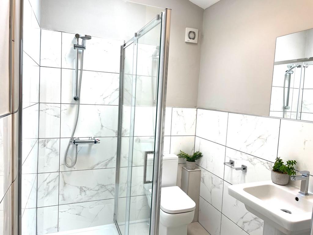 Modern bathroom featuring a glass-enclosed show...