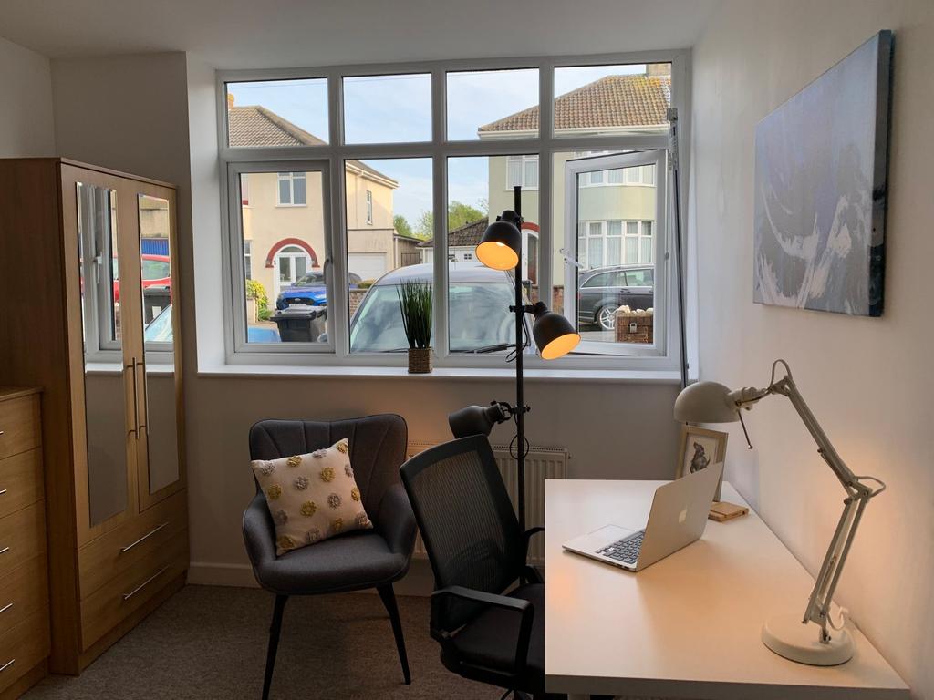 Bright, neatly furnished bedroom with a large f...