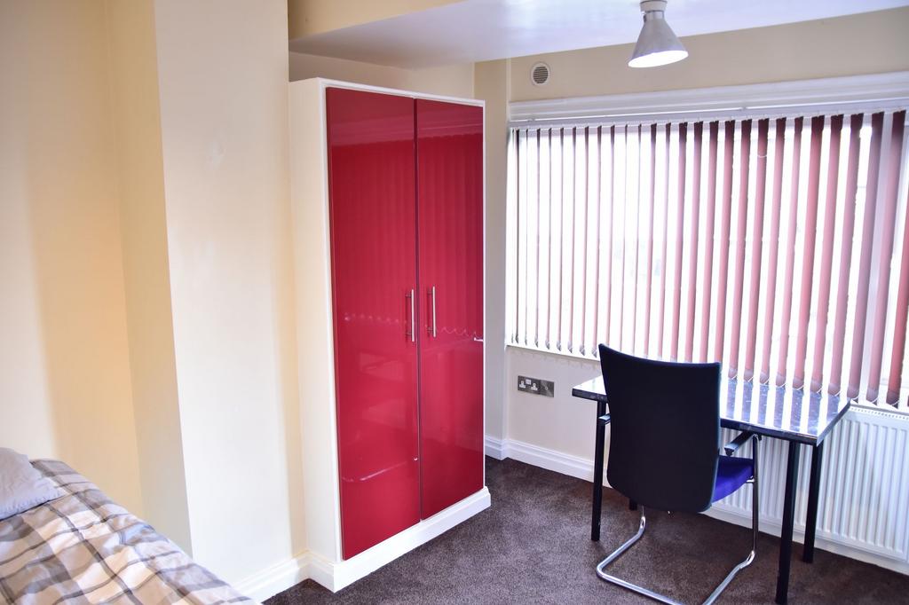 A cozy single bedroom featuring a bed, a vibran...