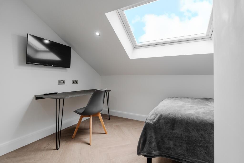 A bright and well-maintained bedroom featuring ...