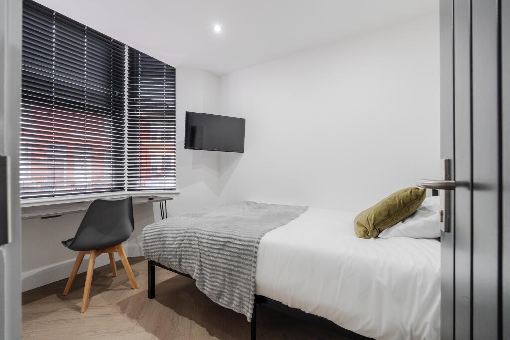 A bright and tidy single bedroom featuring a co...