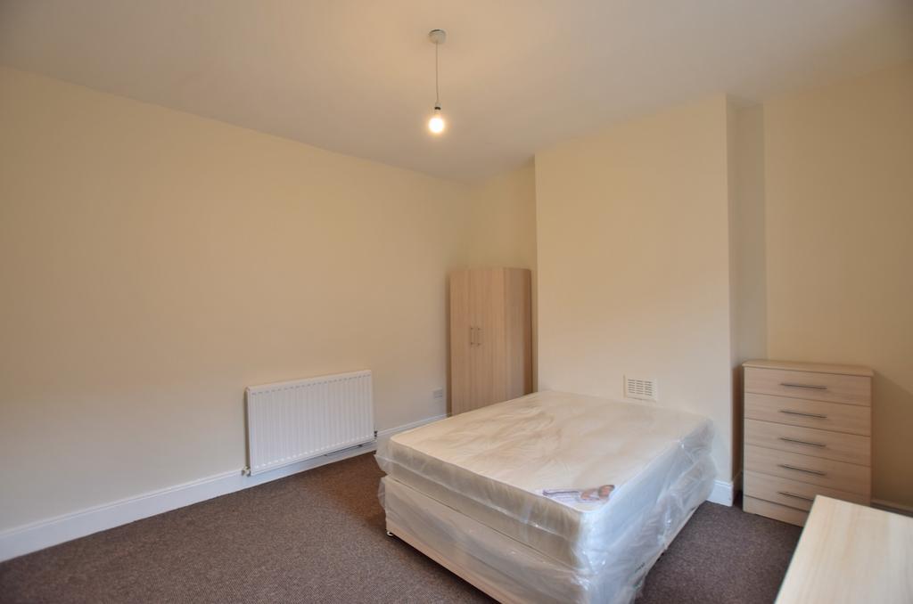 Bright, neutrally decorated bedroom with a doub...