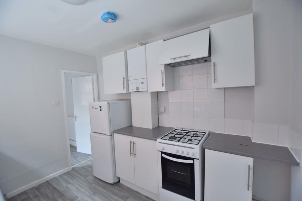 Bright, modern kitchen with white cabinetry, ga...